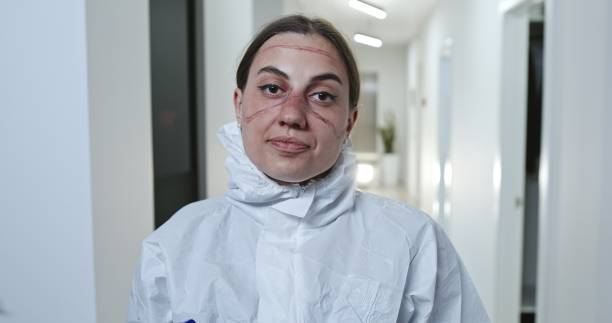 enfermera o médico con ropa protectora con las gafas y la mascarilla facial extraídas mirando la cámara en el hospital antes de volverse a alejarse durante la pandemia de coronavirus covid-19 - doctor tired protective workwear sadness fotografías e imágenes de stock