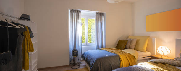istock Modern bedroom with two singles beds with clean bed sheets and large pillow above. White wall 1299983619
