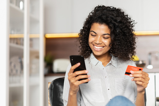 Adolescente afroamericana sosteniendo tarjeta de crédito photo