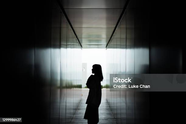 Silhouette Of Asian Woman Standing Against Dark Corridor In A Park Stock Photo - Download Image Now