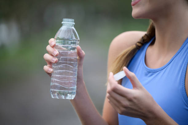 istock Young woman holding plastic bottle of water after workout 1299986587