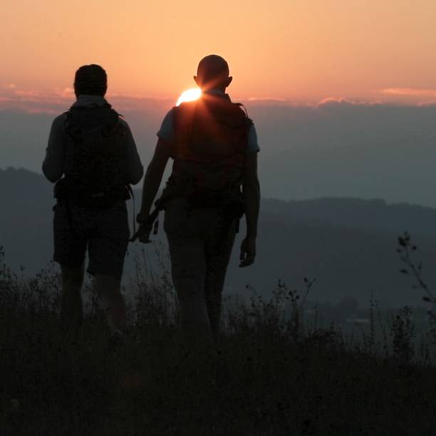 istock Friends hike up mountain ridge at sunrise 1299986670
