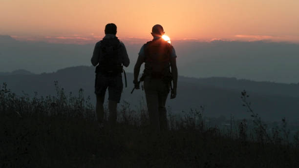istock Friends hike up mountain ridge at sunrise 1299986760