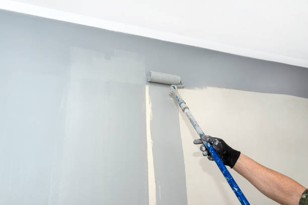 istock The painter paints the room gray with a paint roller on an extended stick at home. 1299989140