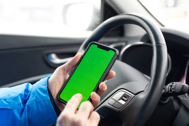 close-up of man hands holding chroma key green screen smart phone in car - mobility working digital tablet people imagens e fotografias de stock