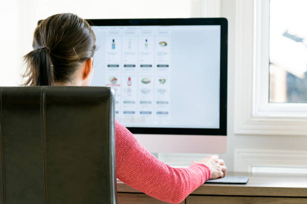 istock Woman Grocery Shopping Online on her Computer from Home 1299992096