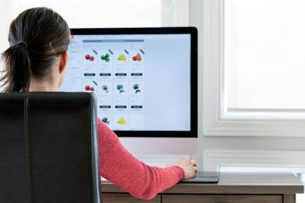 istock Woman Grocery Shopping Online on her Computer from Home 1299992173