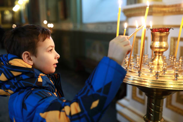 istock Child with lit candle in cathedral 1299992383