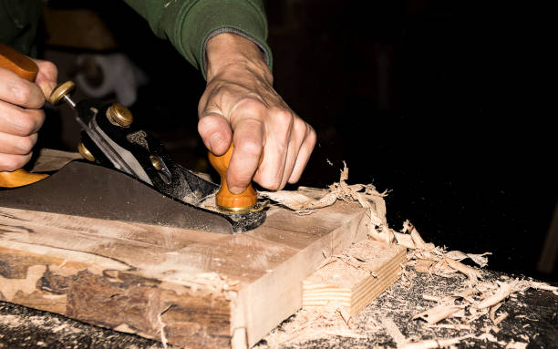 istock carpenter works with knife machine on wooden plank on work table and throws chips 1299993985