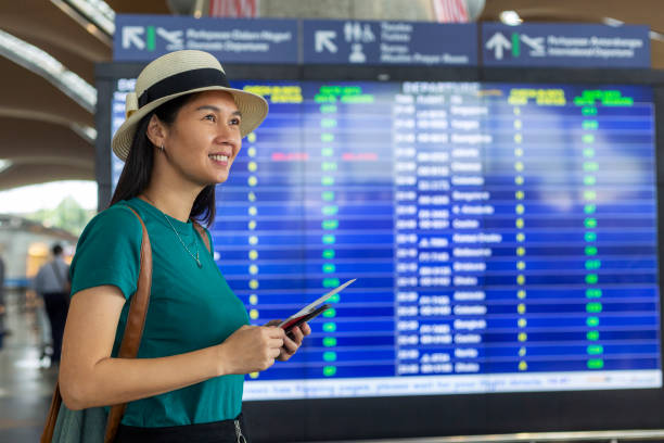 istock female traveler checking her flight in time board 1299994718