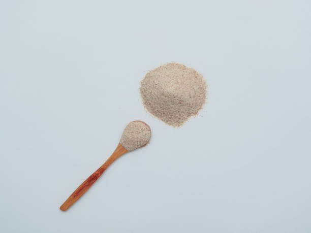 istock Psyllium in wooden spoon on white background top view, flat lay 1299994747