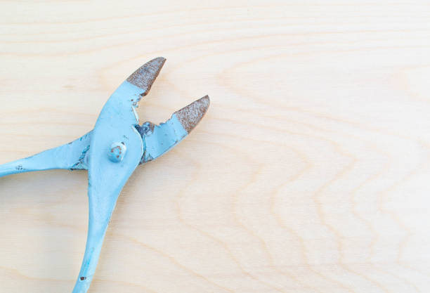 Old fashioned kids pliers on wood background