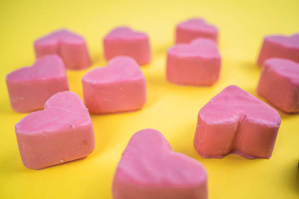 istock Valentines day pink hearts on yellow background 1299995161