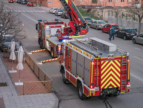 San Sebastián de los Reyes, Madrid, Spain; 01-30-2021: Firefighters checking the facades and roofs of buildings mounted on a telescopic ladder truck after the passage of the storm Filomena