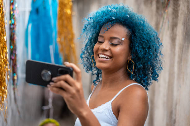 mulher usando smartphone no carnaval - blue hair - fotografias e filmes do acervo