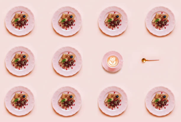 istock Geometric pattern with Pancakes on pink plate and cup of coffee  on pink background. Top view, close up 1299995577