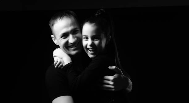 istock father and daughter on black background 1299998380