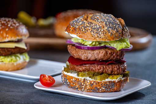 Lunch or dinner with tasty vegetarian hamburgers made from plant based grilled burgers, fresh bakes buns and organic vegetables close up
