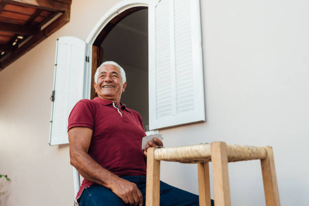 istock Senior man laughing while playing cards in the yard 1299999559