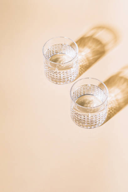istock Glass of water on pastel background with hard shadow 1300002638
