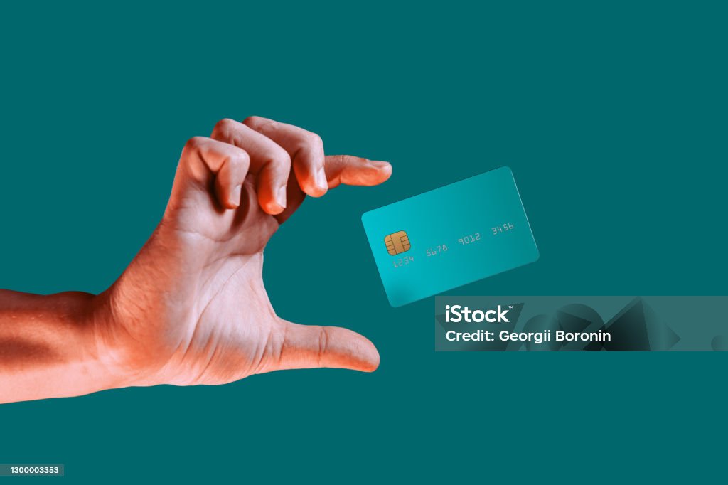 Close up male hand and levitating template mockup bank credit card with online service isolated on green background Close up male hand and levitating template mockup bank credit card with online service isolated on green background. High quality photo Credit Card Stock Photo
