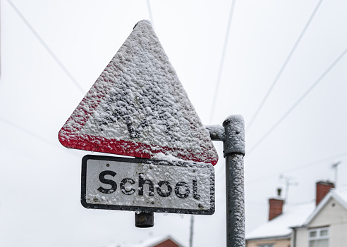 A school warning sign on a road covered with snow during a blizzard which caused schools to close.