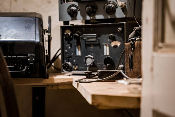 German ww2 Second World War communications bunker secret message dispatch with light and electric sign warning caution communicating in morse code radio set enigma button on desk operator