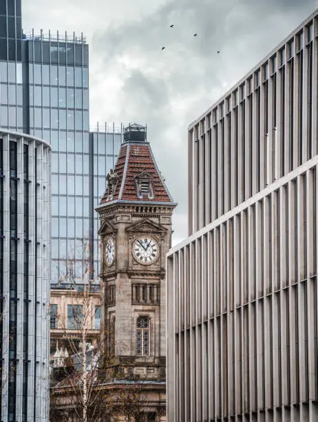 This was taken during the coronavirus lockdown whilst the city was deserted and silent. An old clocktower sandwiched between modern architecture.