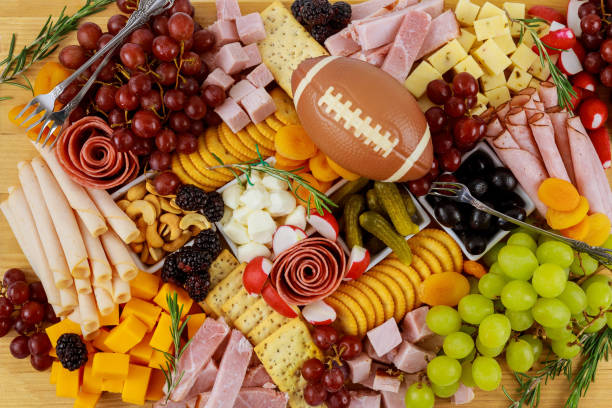Charcuterie board with cheese, grape, ham and crackers.