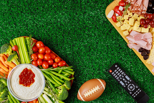 Party table with food and drink for watching american football game.