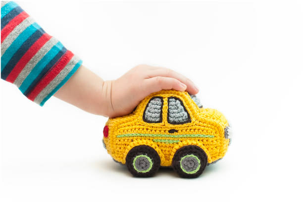 istock Small knitted yellow baby machine on white background. 1300004800