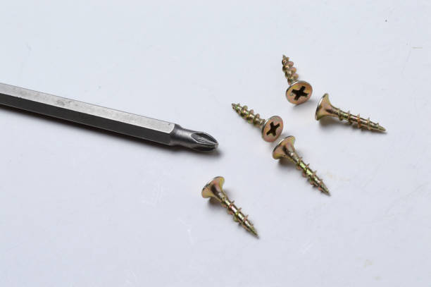 istock several screws and a bit from a screwdriver lie on a light background. close-up. 1300005188
