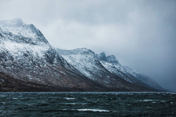 Cold desolate, remote snow covered mountains, extreme terrain in northern arctic fiords of Norway