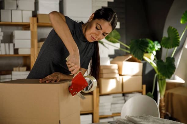 istock Diligent young woman taping a box in her office 1300008609