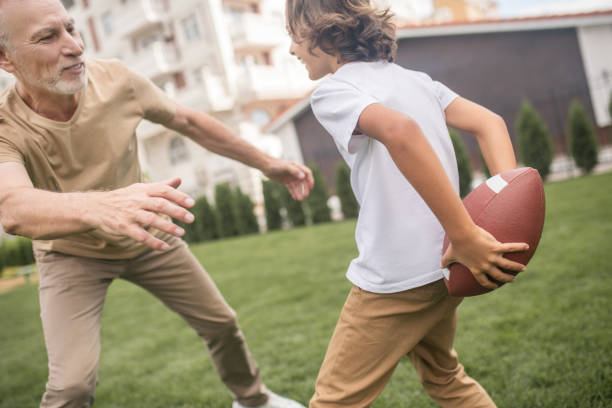 istock Dark-haired boy and his dad looking excited while playing ball 1300008861