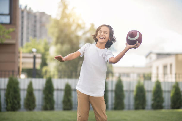 istock Dark-haired boy in a white tshirt playing with a ball 1300008943
