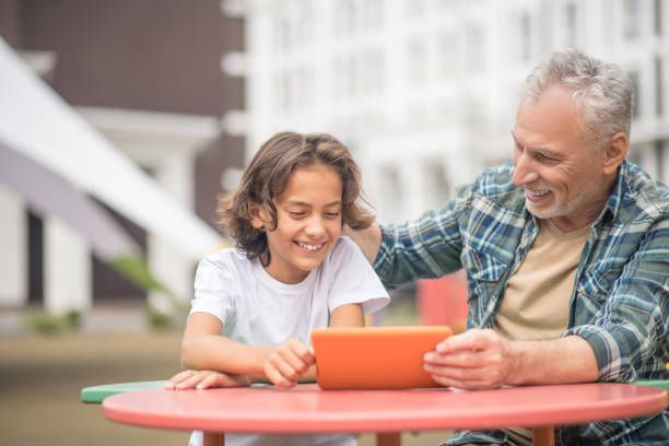 istock Son and dad watching something on a tablet and looking involved 1300009055