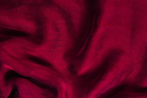istock Soft smooth burgundy silk fabric background. Fabric texture. 1300009264