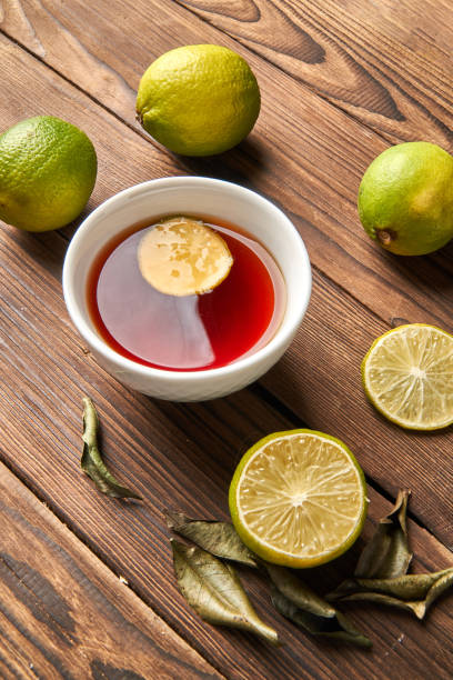 istock Tea and lime on a wooden background 1300011454