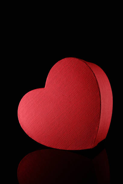 istock Red textured heart shape gift box on black backdrop, gift concept 1300011477