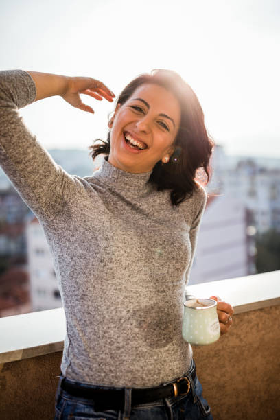 istock Happy woman drinking coffee on the balcony 1300011637