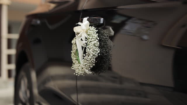 Decoration wedding car with wedding flowers and satin ribbons. Wedding Decor.The Design of the Wedding Decorations. Flowers on the wedding modern car