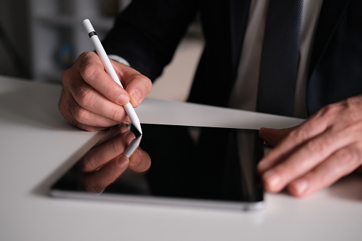 Businessman Signing Digital Contract On Tablet Using Stylus Pen