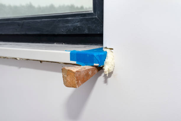 istock Newly installed white conglomerate window sill inside the room. Propped on a peg and filled with mounting foam from the bottom. 1300012767