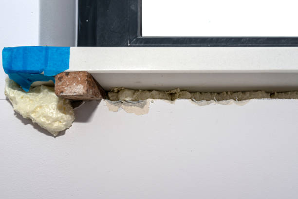 istock Newly installed white conglomerate window sill inside the room. Propped on a peg and filled with mounting foam from the bottom. 1300012861