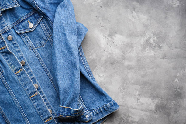 istock Blue denim jacket on a gray background, place for text. Flat lay. Classic jeans texture. 1300012926