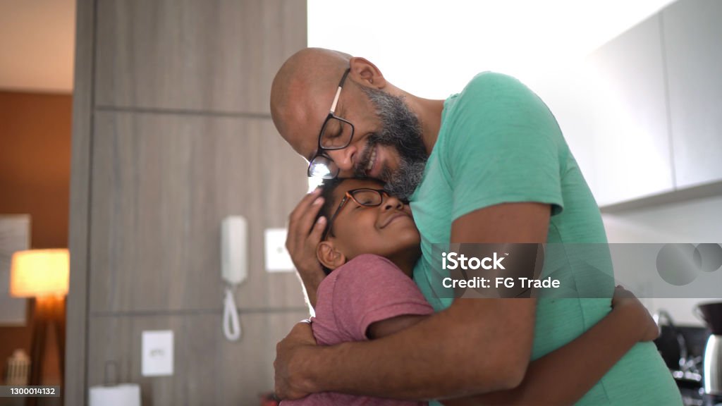 Father embracing son at home Father Stock Photo