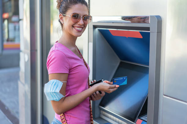 istock Young woman at the ATM device 1300015132