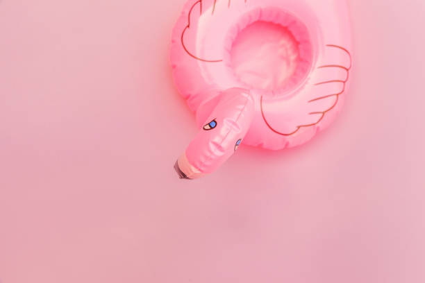 istock Summer beach composition. Simply minimal design with Inflatable flamingo isolated on pastel pink background. Pool float party, trendy celebrity fashion concept. Flat lay top view copy space 1300016841