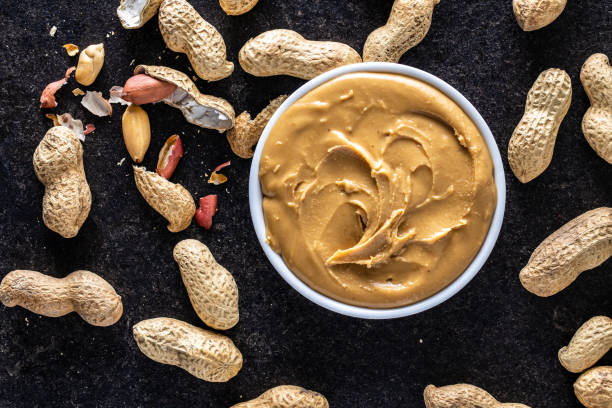 istock Peanut butter in bowl and peanuts 1300018062